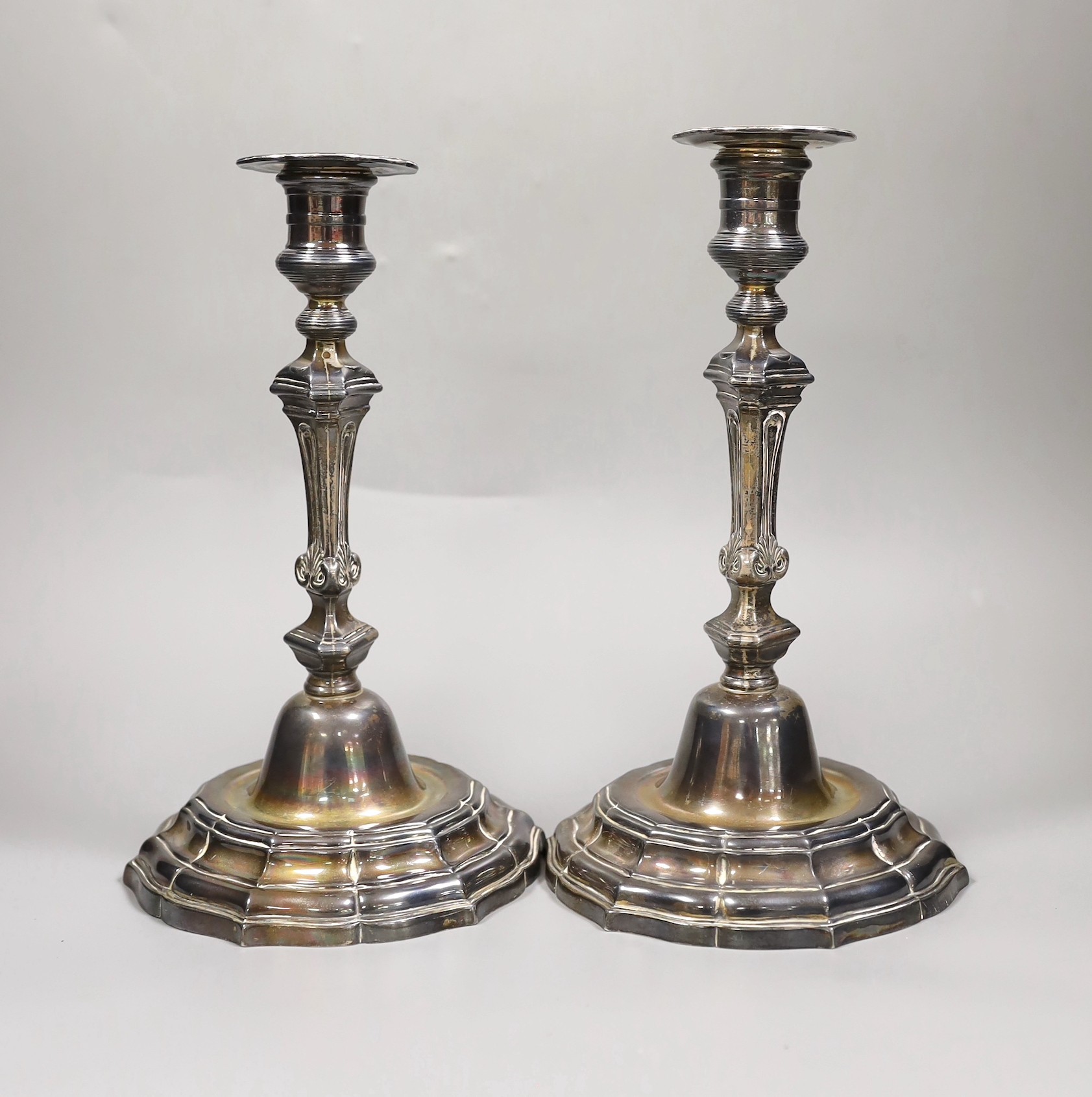 A pair of French Louis XVI cast white metal candlesticks and sconces, with waisted knopped stems, on shaped circular bases, maker, Jean Schoutheer, Dunkirk mark, circa 1775, height 26.2cm, 36oz.